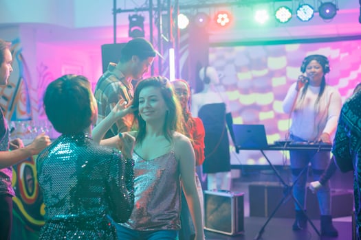 Girlfriends talking while relaxing on dancefloor at nightclub discotheque. Smiling women dancing together while partying and attending live electronic music concert in club photo