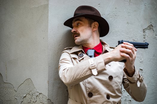 Detective taking cover and aiming with his handgun photo
