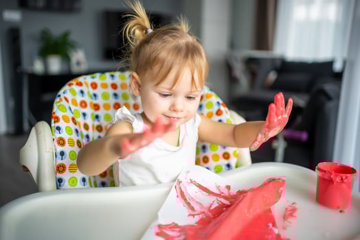 Cute little girl painting with fingers at home. Creative games for kids. Stay at home entertainment photo