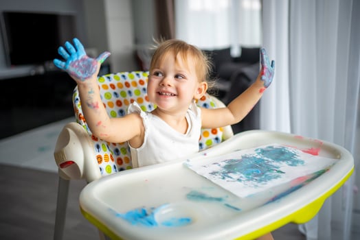 Cute little girl painting with fingers at home. Creative games for kids. Stay at home entertainment photo