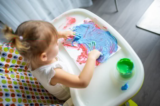 Cute little girl painting with fingers at home. Creative games for kids. Stay at home entertainment photo
