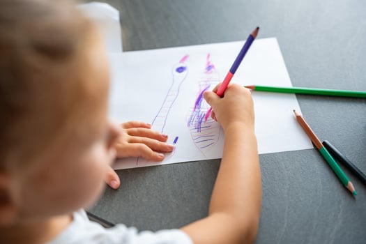 little girl draws with colored pencils in home. photo