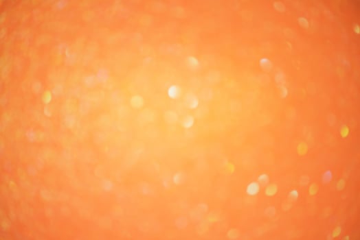 Sparkles defocus light. Glitter paper defocus as background. Orange background light and shadow. photo