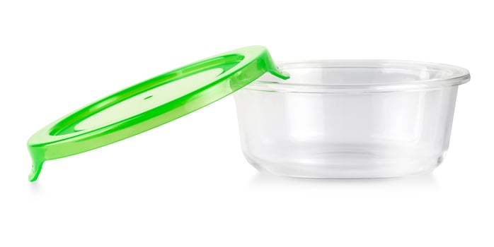 Glass food container with green plastic lid isolated on white photo