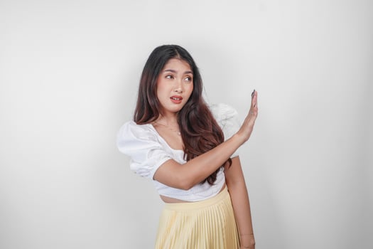 Young Asian woman isolated on white background, looks afraid, gesturing decline by her hand, frightened and nervous. photo