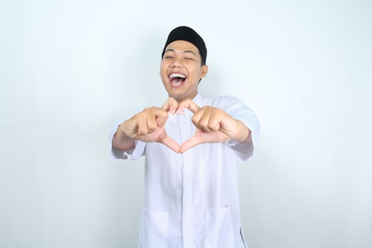 excited asian muslim man showing heart shape isolated on white background photo