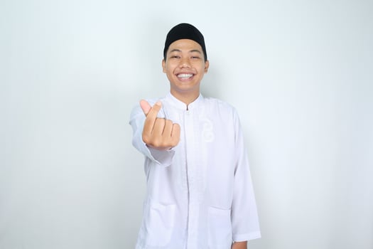 excited asian man muslim give korean heart shape at camera isolated on white background photo