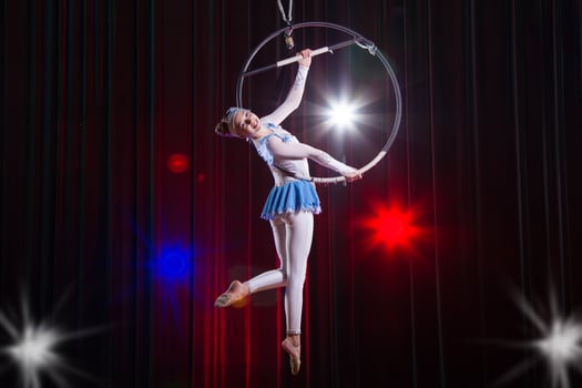 Performs a circus girl actress. Circus aerial gymnast on the hoop. Acrobatics. Teenager performs an acrobatic trick in the air photo