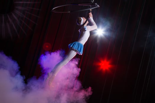 Performs a circus girl actress. Circus aerial gymnast on the hoop. Acrobatics. Teenager performs an acrobatic trick in the air photo