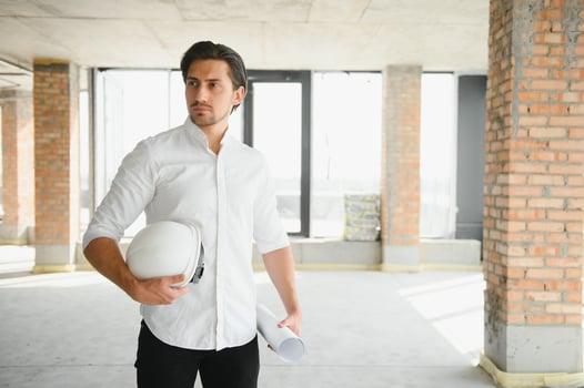 Portrait of man architect at building site. Confident construction manager wearing hardhat. Successful mature civil engineer at construction site with copy space. photo
