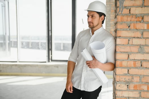 Portrait of man architect at building site. Confident construction manager wearing hardhat. Successful mature civil engineer at construction site with copy space. photo