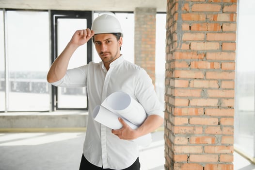Portrait of man architect at building site. Confident construction manager wearing hardhat. Successful mature civil engineer at construction site with copy space. photo
