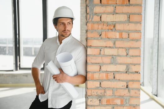 Portrait of man architect at building site. Confident construction manager wearing hardhat. Successful mature civil engineer at construction site with copy space. photo