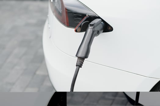Close up of the Hybrid car electric charger station with power supply plugged into an electric car being charged. photo