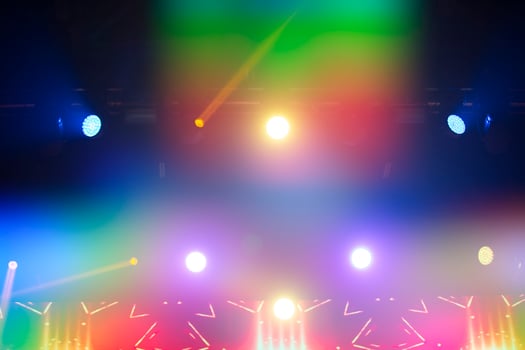 Bright festive multi-colored stage lighting with optical flare and rays from lighting lamps. photo
