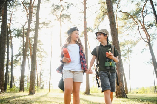 Little boy and girl go hiking on a forest road photo