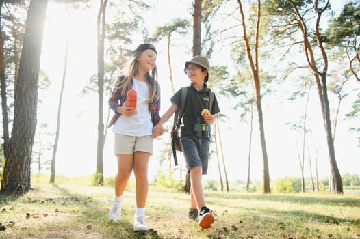 Little boy and girl go hiking on a forest road photo