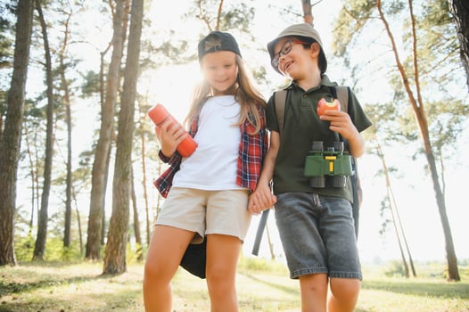 Little boy and girl go hiking on a forest road photo