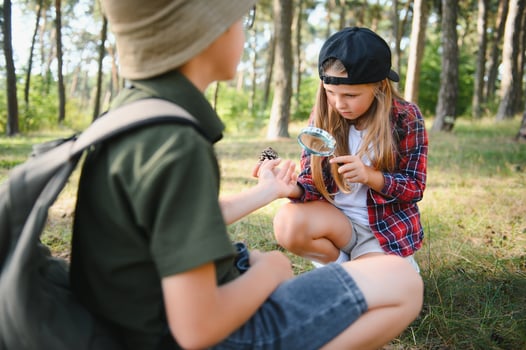 Kids exploring nature with magnifying glass. Summer activity for inquisitive child. photo