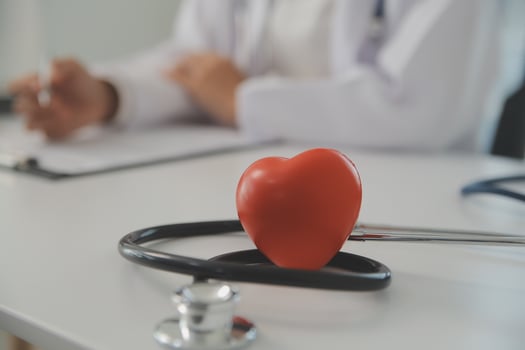 Hands of doctor woman holding red heart, showing symbol of love, human support to patient, promoting medical insurance, early checkup for healthcare, cardiologist help. Close up of object photo