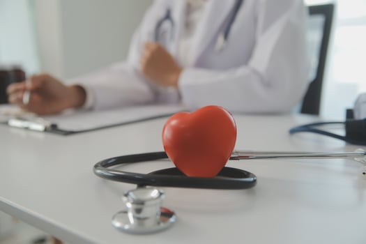Hands of doctor woman holding red heart, showing symbol of love, human support to patient, promoting medical insurance, early checkup for healthcare, cardiologist help. Close up of object photo