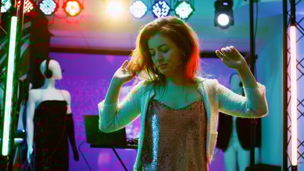 Young person dancing at nightclub, showing cool dance moves in discotheque with funky music. Cheerful girl partying and having fun at electronic party, stage lights on dance floor. Handheld shot. photo