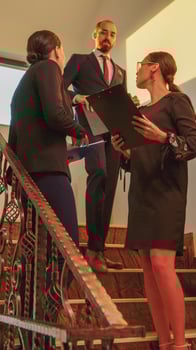 Businesswomen meeting on stairs in finance corporate company analyse graphs standing on stairscase. Group of professional successful businesspeople working in modern financial building photo