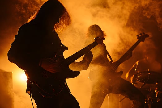 AI Generated Long-haired rock musician with electric guitar playing in dark smoke with orange lighting. photo