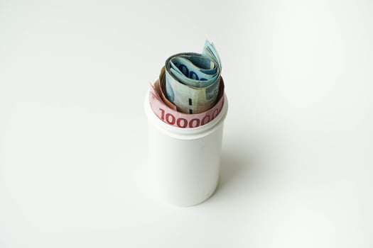 Indonesian money rupiah is in a white cup with a isolated white background photo