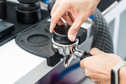 Barista holding portafilter with ground coffee photo