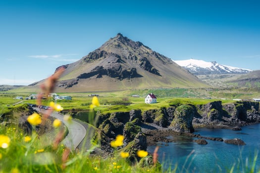 Arnarstapi fishing village with nordic house and stapafell volcano mountain by basalt rocks formation in Snaefellsnes peninsula at Iceland photo