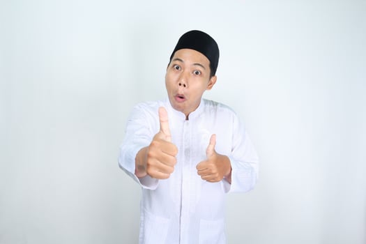 shocked asian man muslim show thumbs up isolated on white background photo
