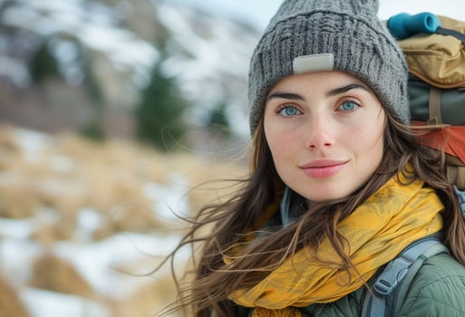 AI generated Young Female Hiker With Backpack Pausing During a Snow-Capped Mountain Trek in Winter photo