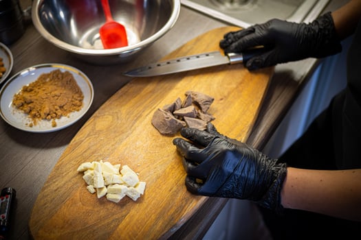 Woman cooking tasty melted chocolate on table in kitchen. photo
