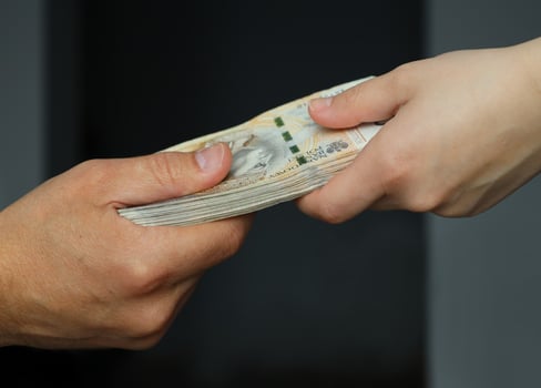 male and female hands holding a bundle of 200 zloty banknotes. selective focus photo