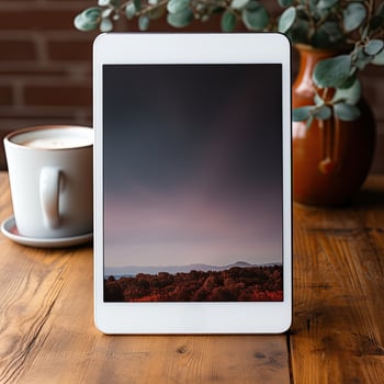 AI Generated Tablet showcasing a scenic wallpaper beside a cup of coffee on a wooden table. photo