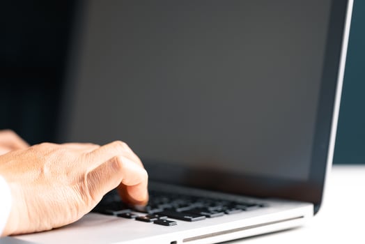 Businesswoman hand typing on laptop computer while working in white modern office room. photo