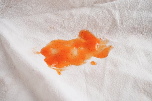 Dirty spicy sauce stain on cloth to wash with washing powder, cleaning housework concept. photo