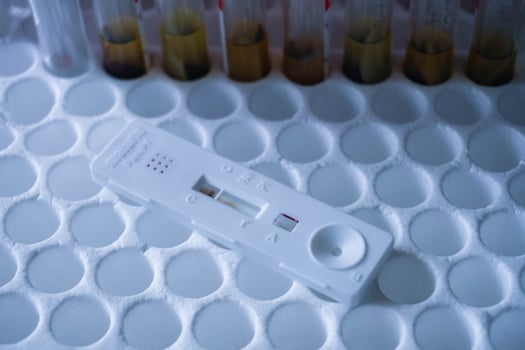 Rapid test cassette malaria on a above the red vacuum tube. shows a negative result.Copy space photo