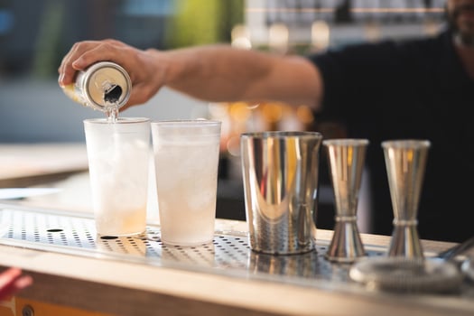 the bartender behind the bar makes an alcoholic cocktail photo