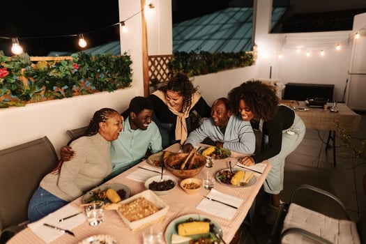 Happy African family dining together on house patio photo