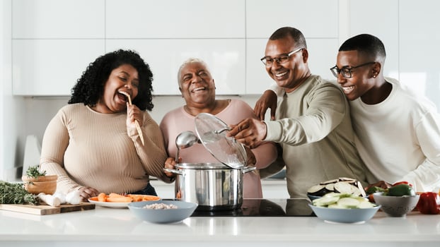 Happy Hispanic family having fun cooking together in modern kitchen - Food and parents unity concept photo