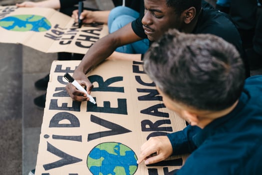 Multiracial activists preparing protest signs against climate change - Global warming concept photo