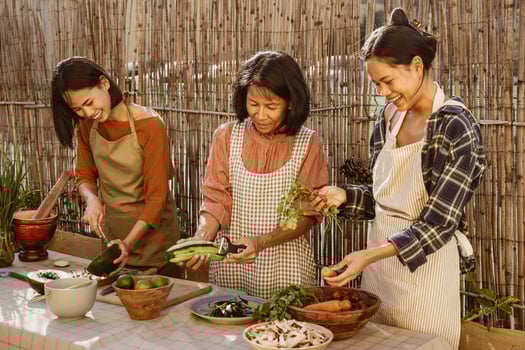 Happy Southeast Asian family having fun preparing Thai food recipe together at house patio photo