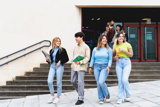 Young diverse students leaving university after lesson - Youth and education concept photo
