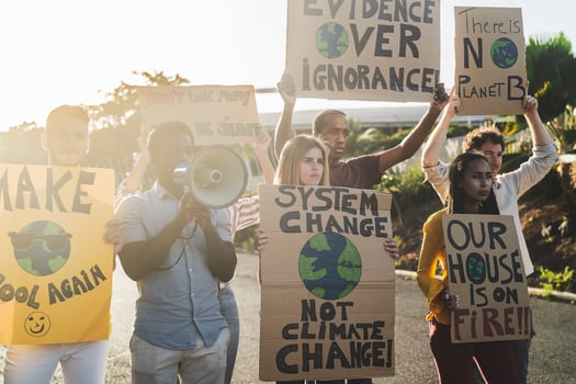 Group of activists protesting for climate change - Multiracial people fighting on road holding banners over environments disasters - Global warming concept photo