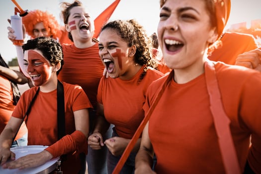 Football fans exulting while watching soccer game at stadium - Women with painted face and drum encouraging their team - Sport entertainment concept photo