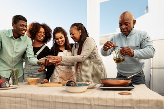 Happy African family preparing a dinner together on house patio photo