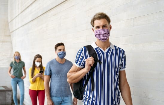 Young people from different cultures and race waiting in queue outside shop market while keeping social distance - Corona virus spread prevention concept photo