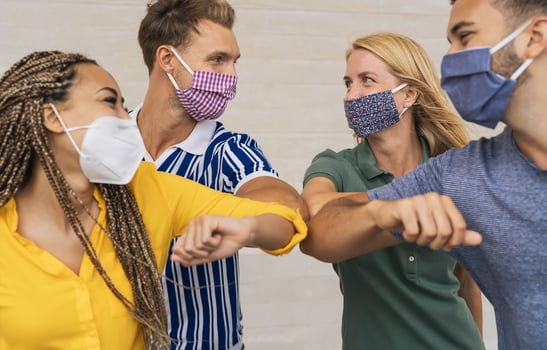 Young friends wearing face protective mask doing new social distancing greet with elbows bumps for preventing corona virus spread - Physical distance and friendship safety greetings concept photo